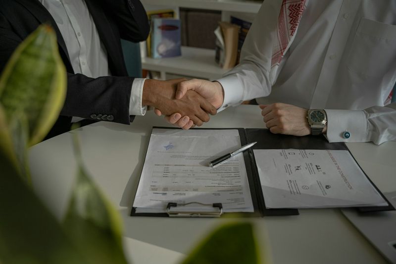 Aperto de mãos sobre contrato assinado